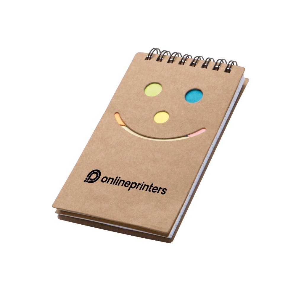 Ein kleines Spiralnotizbuch mit einem braunen Kartoneinband. Der Einband ist mit einem Smiley-Design mit ausgeschnittenen Augen und Mund versehen, das den Blick auf bunte Haftnotizen im Inneren freigibt. Unter dem Smiley ist das Wort „onlineprinters“ aufgedruckt.